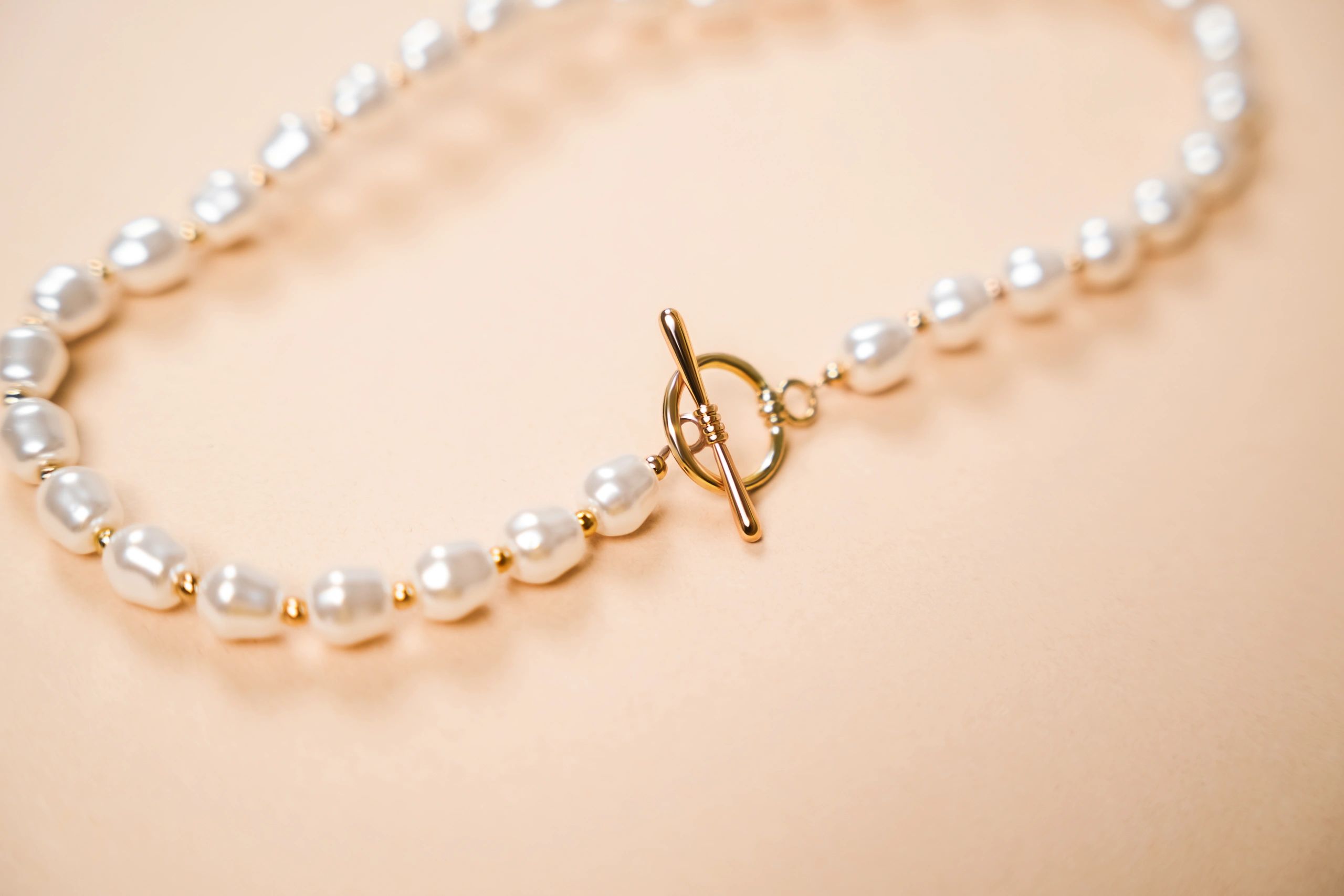 Elegant pearl necklace styled on a neutral surface
